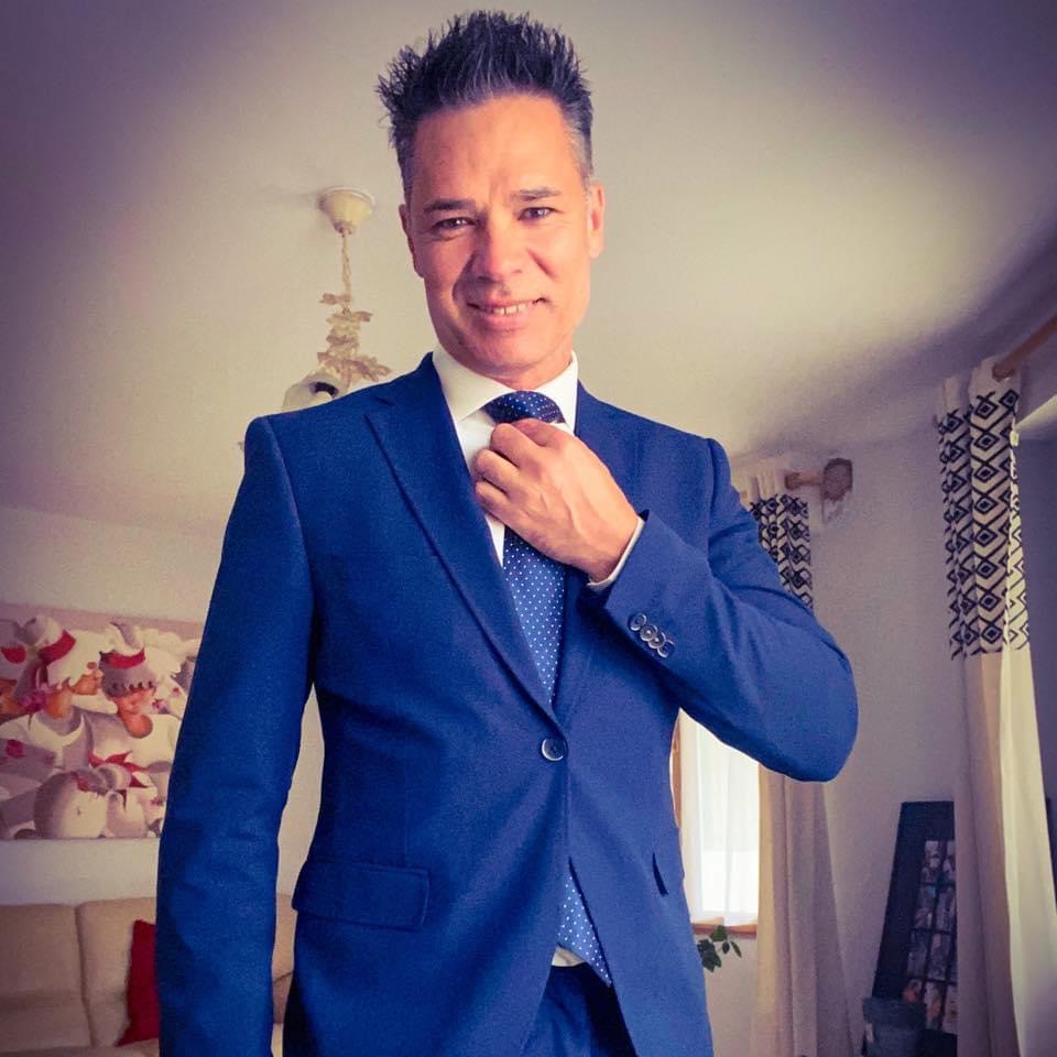 chauffeur-prive-vtc-en-costume-bleu-ajustant-sa-cravate-illustrant-lelegance-et-le-professionnalisme-de-maison-v-signature